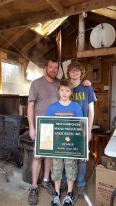 Chris, Zach and Kam White of Tappy Sapmaster and Sons Sugarhouse in Loudon proudly showing their new NHMPA sign